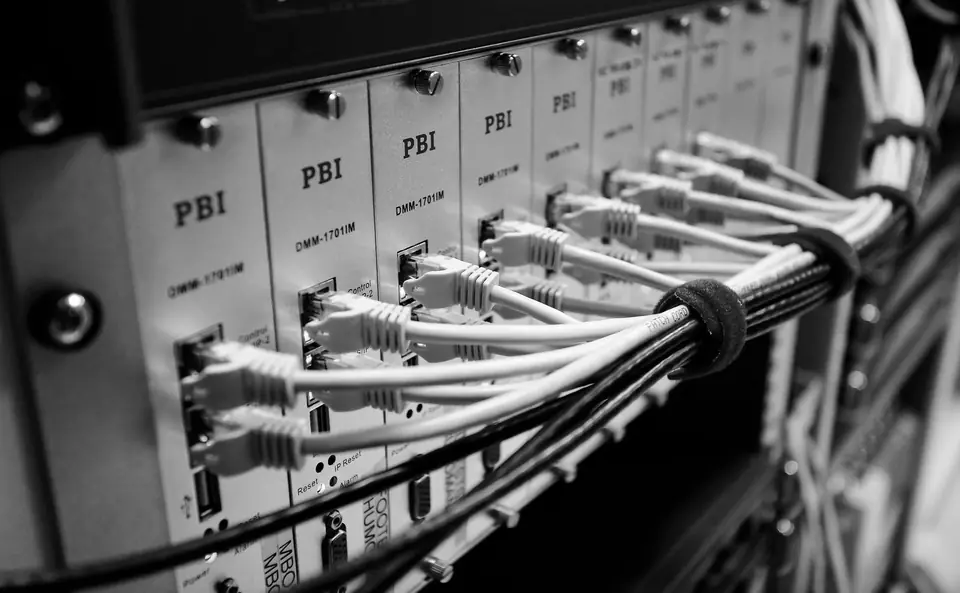 Rows of network cables plug into a rack of labeled switch modules.