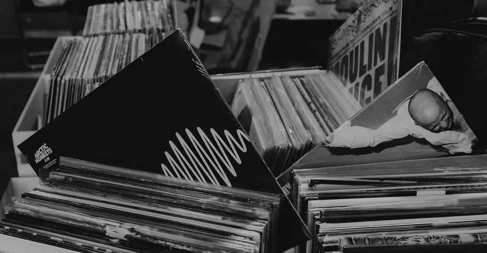 Crates packed with vinyl records, several album sleeves leaning out at odd angles.