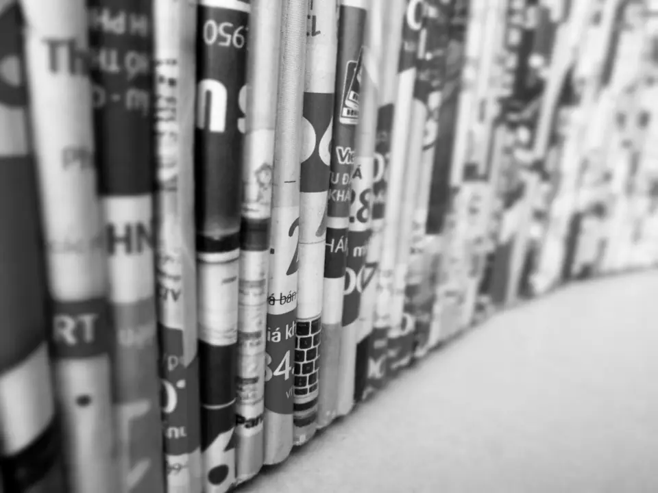 A long row of magazine spines with printed titles stands on a shelf, fading out of focus.