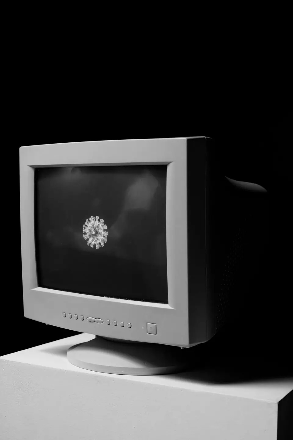 A beige tube monitor on a white pedestal displays a small bright shape against black.