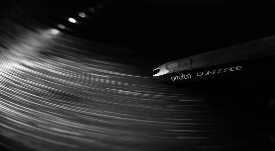 A close-up of a turntable stylus labeled Ortofon Concorde on the grooves of a spinning record.